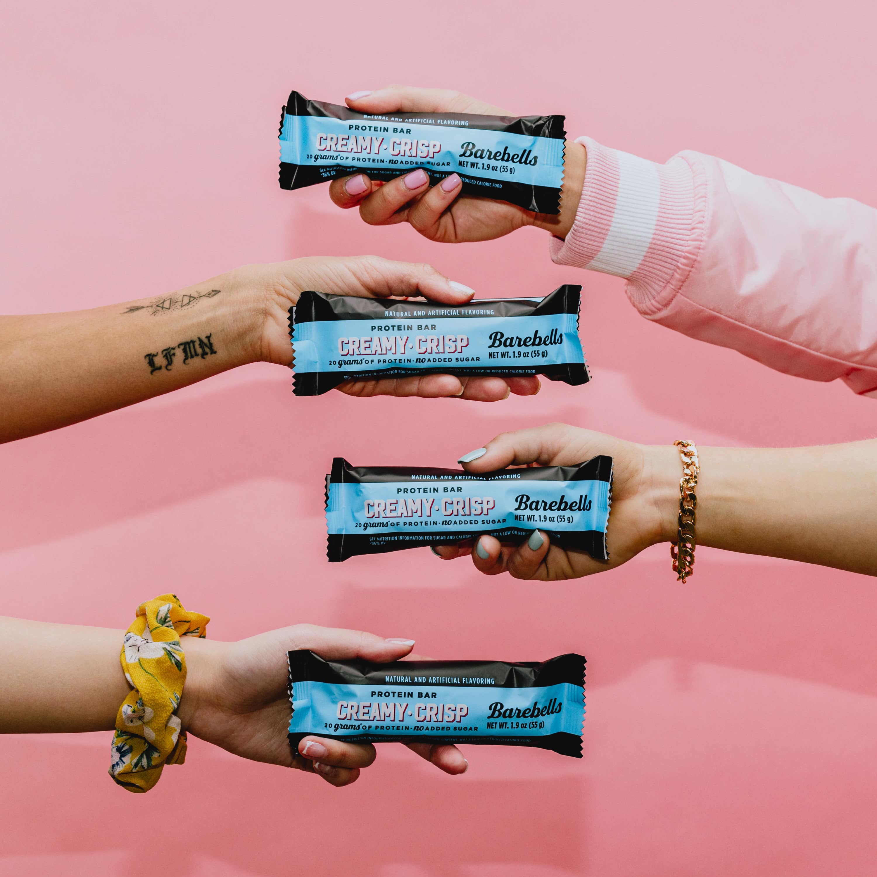 barebells creamy crisp protein bar in hand model lifestyle image in studio