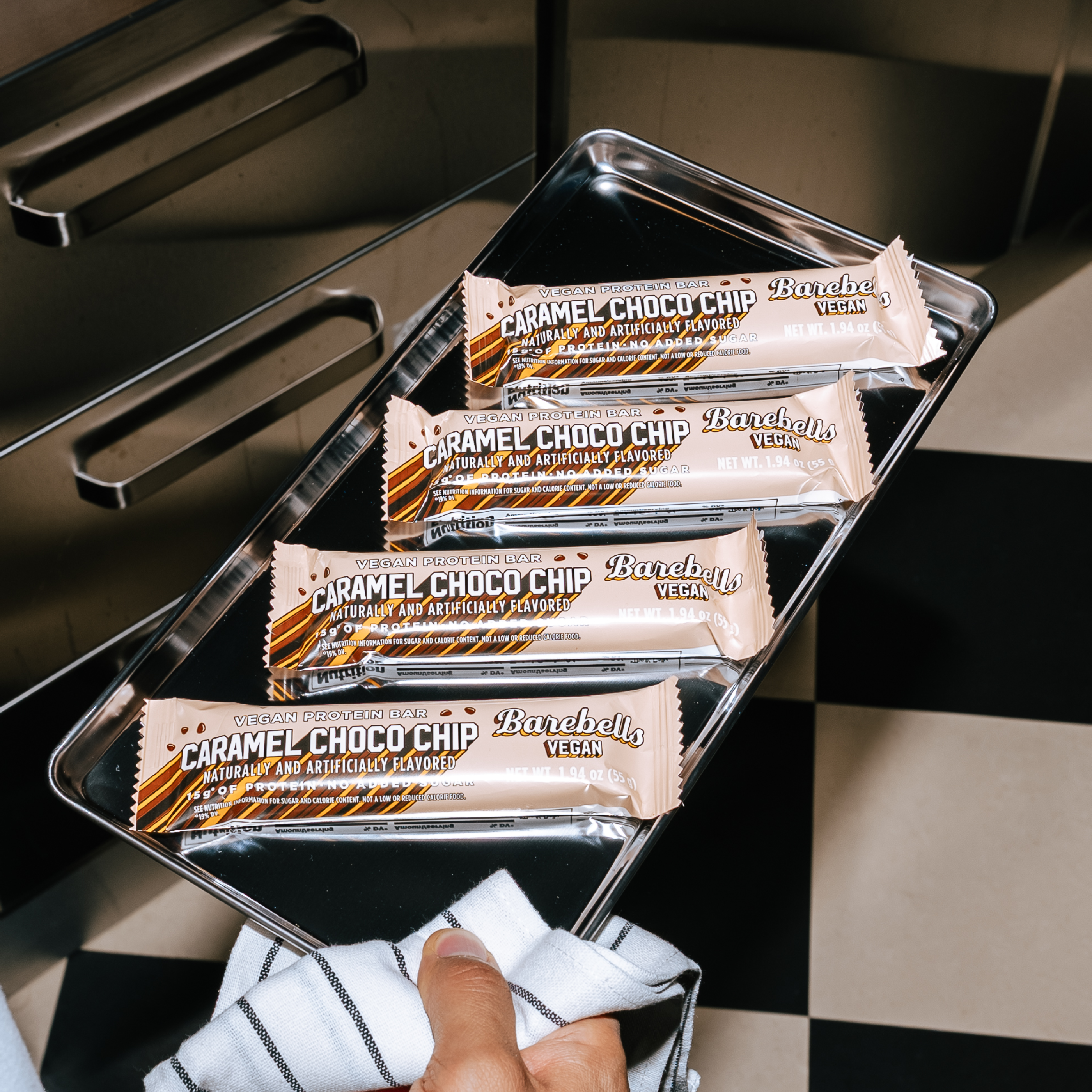 Stack of caramel choco chip vegan protein bars in a metal tray.